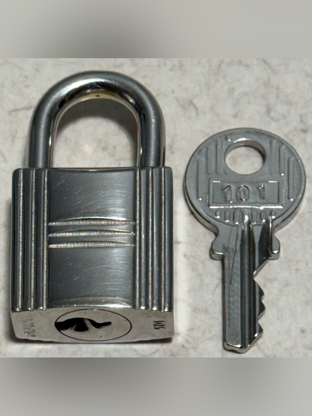 Hermès Cadena Padlock and Key Set in Silver-toned or palladium-plated metal.